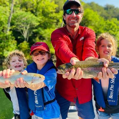 Bryan Sanders is seen holding a fish while his sons are holding an another one